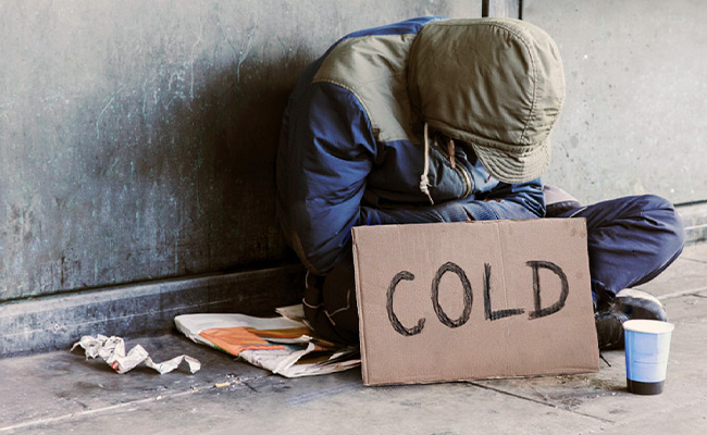 cold person sitting on sidewalk